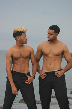 Two young Afro men talk on the coast. 