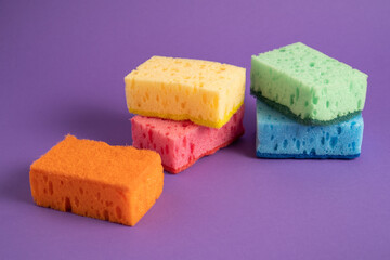 Kitchen cleaning sponges. Multicolored sponges for cleaning. Colored sponges on purple background. Scrub Sponge