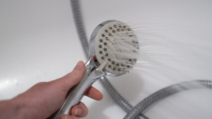 Shower head in bathroom with water drops flowing. Clean water concept. Shower funnel. Shower faucet with splashing water