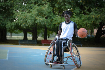 African man with a disability caused by polio playing basketball, champion athlete on wheelchair, concept of determination and mental toughness, accessibility and diversity - obrazy, fototapety, plakaty
