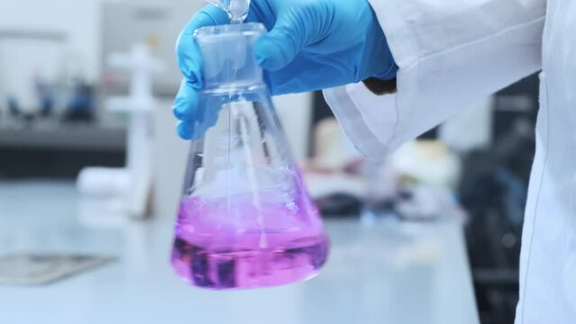 Scientists titrating samples to determine the exact concentration of the solution in analytical laboratory. Water analysis in the moder laboratory. 