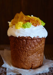 Glazed easter cake decorated with dried orange and pear slices on dark background, copy space. Happy Easter holidays. Kulich