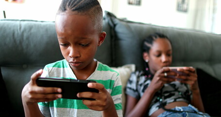 Children addicted to technology, kids watching screens at home absorbed in their phones