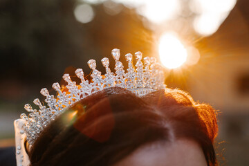 A crown on the bride's head at sunset.