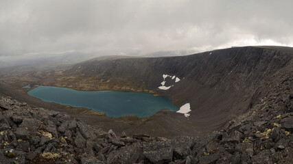 Lake academic khibiny with turquoise water in the mountains in autumn on a cloudy day. view from above
