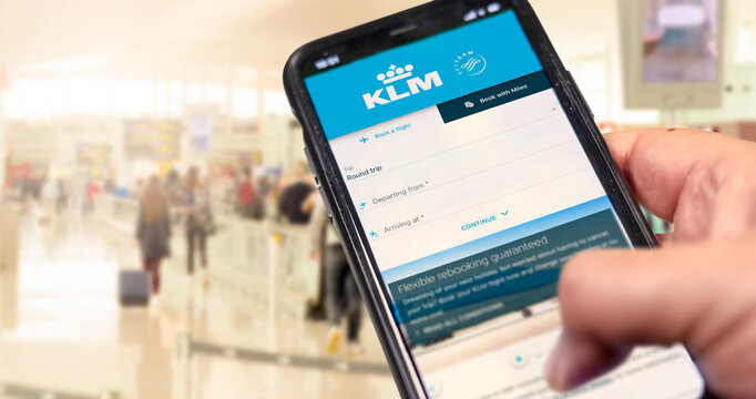 Hand holding a phone with KLM Airlines flight booking application