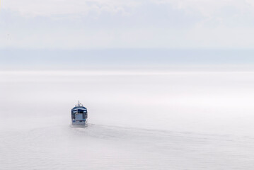 A ship sailing on the lake in the fog