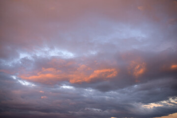 Dense painted clouds at sunset against a blue sky