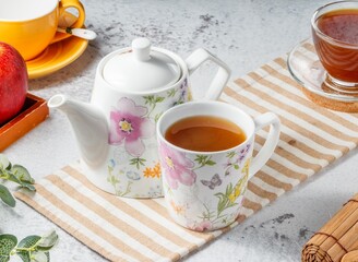 Healthy Ginger tea with lemon in beautiful cup on mat with grey background breakfast drink