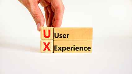 UX user experience symbol. Concept words UX user experience on wooden blocks on beautiful white table white background, copy space. Businessman hand. Business and UX user experience concept.