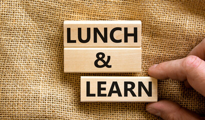 Lunch and learn symbol. Concept words Lunch and learn on wooden blocks. Beautiful canvas table canvas background. Businessman hand. Copy space. Business, educational and lunch and learn concept.