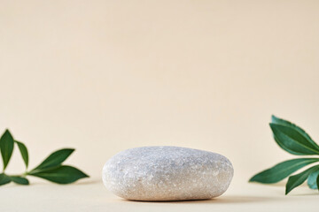 Cosmetic background for product presentation. Gray stone podium and  leaves on beige background . Front view