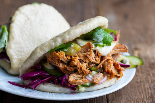 Steamed bao buns with pulled pork, pickled cucumber, erd cabbage and mustard mayo