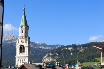 Basilica church steeple and mountain panorama view in Cortina d'Ampezzo, Italy