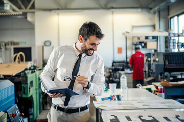 Fototapeta premium A supervisor looking at prints on stack at printing shop.