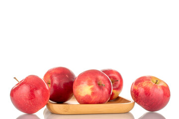 A few sweet organic, red apples on a bamboo tray, macro, isolated on a white background.

