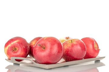 A few sweet organic, red apples on a tray of metal, macro, isolated on a white background.

