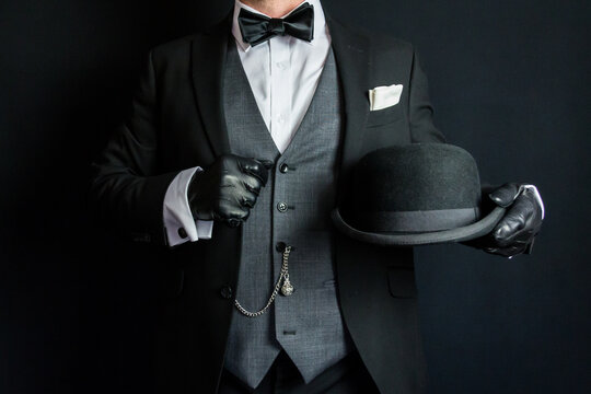 Portrait of Man in Dark Formal Suit and Leather Gloves Holding Bowler Hat. Vintage Style and Retro Fashion of Classic English Gentleman.