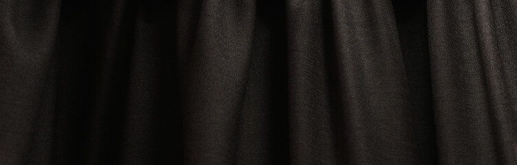 A dark-colored curtain hangs on the wall