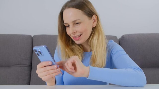 Happy white woman browsing internet news feed on mobile phone. Beautiful blonde female in 40s using modern smartphone for entertainment and communication online. Cheerful person brose social media app