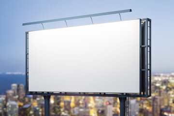 Fototapeta premium Blank white horizontal billboard on cityscape background at night, perspective view. Mockup, advertising concept