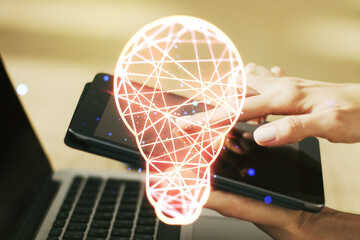 Double exposure of creative light bulb hologram with finger clicks on a digital tablet on background, research and development concept