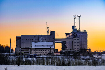 Winter russian landscape with the image of a factory at sunset