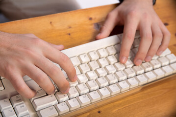 two hands writing in a computer keyboard,
