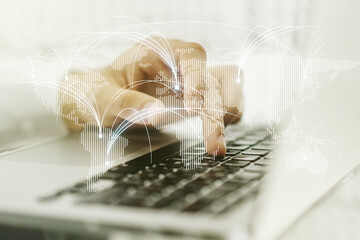 Double exposure of abstract digital world map with connections and hands typing on laptop on...