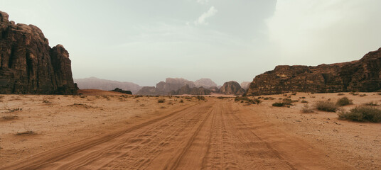 Wadi Rum desert, Jordan, The Valley of the Moon. Orange sand, haze, clouds.