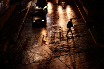 lonely man cross the street in the night 