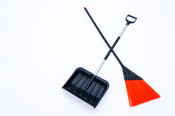 snowy field with black snow shovel and orange broom