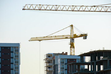 Aerial view of tower cranes and high residential apartment buildings under construction. Real...