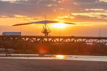 A motor glider at sunset over the bridge