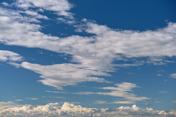 Bright landscape of white puffy cumulus clouds on blue clear sky