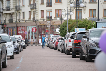 Cars parked in line on city street side. Urban traffic concept