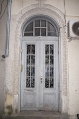 white antique wooden double door with glass and forged decor