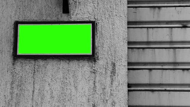 Blank Street Sign Plaque or Billboard with Green Screen on the Wall of an Old House. Black and White Tone. Close Up.  