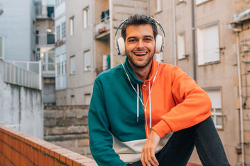 young man with headphones on city street outdoors