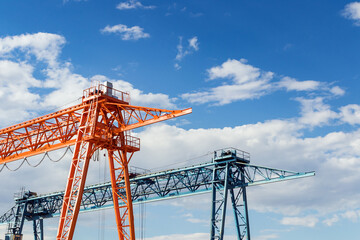 Gantry cranes against a blue sky - obrazy, fototapety, plakaty