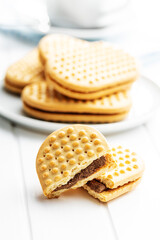 Sweet sandvich cookies. Biscuits with cocoa cream filling on white table.