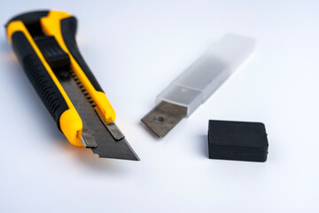 sharp new yellow-black stationery knife and spare blades in a case