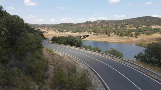 Dron shot Espania Spain open shot sun afternoon sky buildings smog mist paning left covid trees tree front green bus back cars rush hour road covid empty.mp4