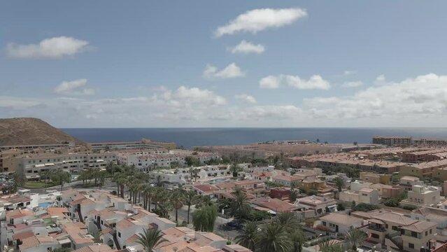 Dron shot Espania Spain Tenerife open shot sun afternoon sky buildings smog water lake paning left moutan sea covid trees tree front green blue back cars rush hour road covid empty sun sunset.mp4