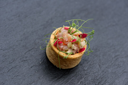 Modernes Fingerfood aus Matjes / Kanapees / Amuse bouche mit essbaren Bl&uuml;ten dekoriert