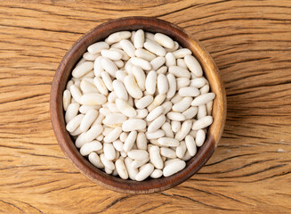 White beans in a bowl over wooden table