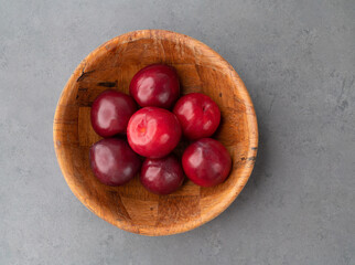 Plums in a bowl over stone background