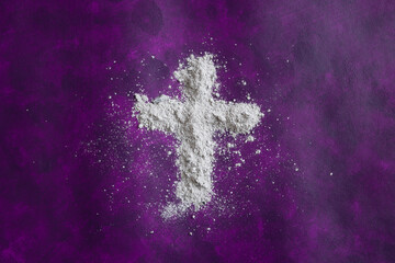 Christian cross of ashes on a deep purple background with copy space