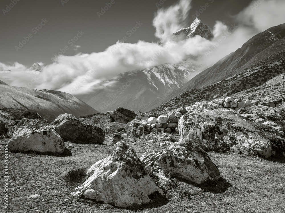 Poster view to stones and vally khumbu with clouds on the peaks in monochrome style in nepal