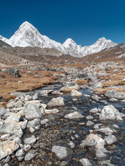 Fototapeta na wymiar view to snow peaks of Himalaya and wild mountain creek under blue sky in Nepal